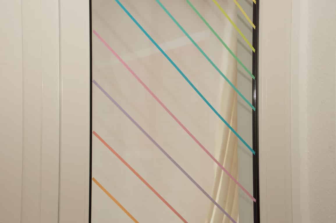 Abgeklebte Fensterscheibe mit buntem Klebeband.
