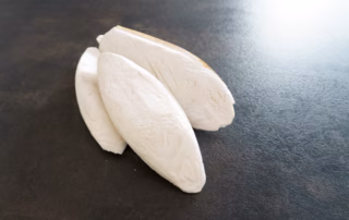 Drei Sepiaschalen für Wellensittiche liegen auf einem Tisch.